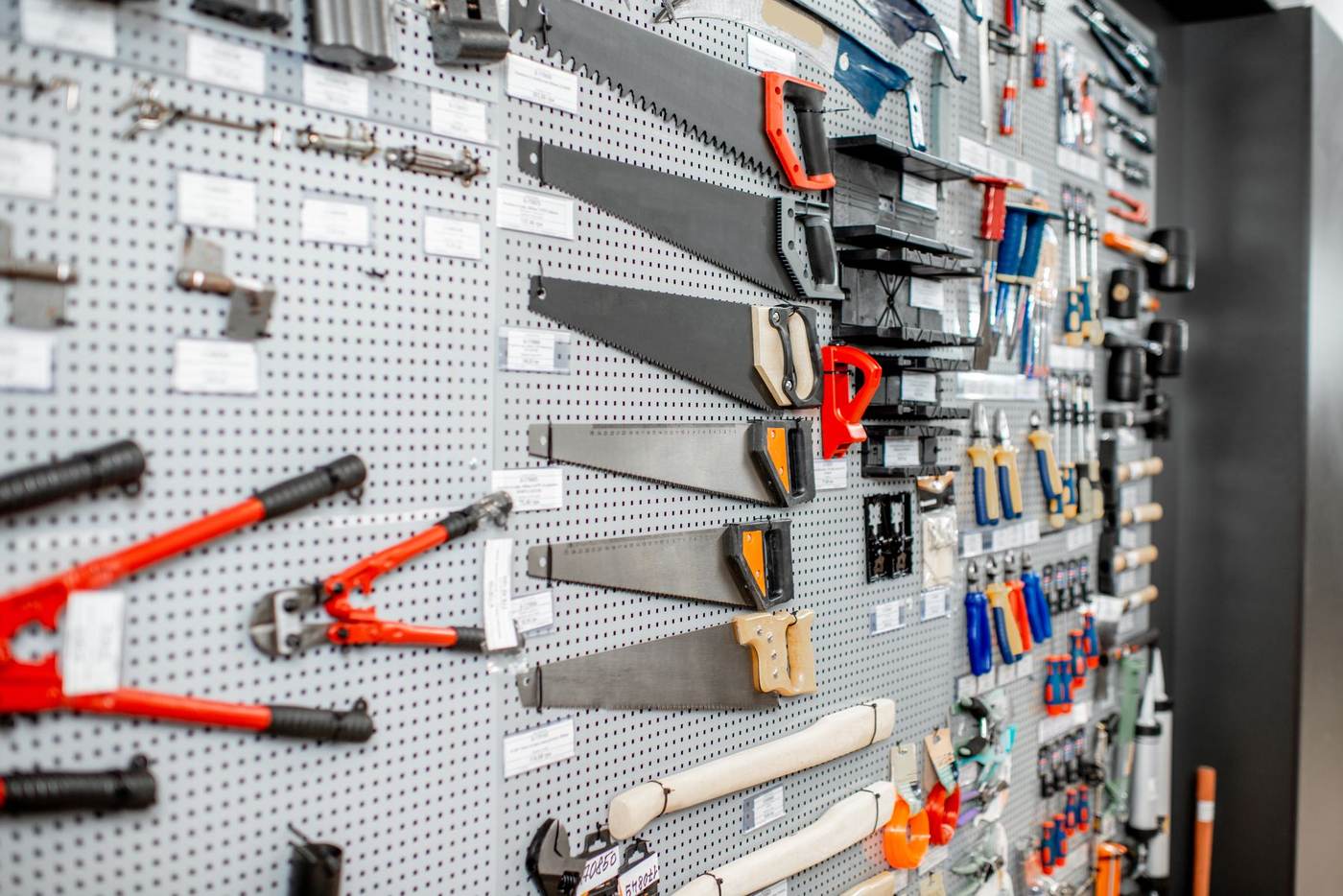 Saws, clamps and hardware displayed on a pegboard wall